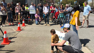 Neighbors march to demand officials make busy road safer for pedestrians